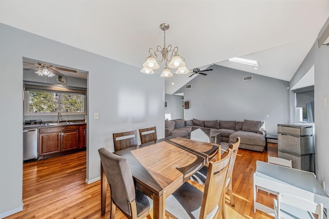 dining area with lofted ceiling, sink, ceiling fan with notable chandelier, and light hardwood / wood-style flooring