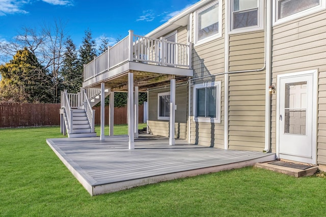 rear view of house featuring a wooden deck and a lawn