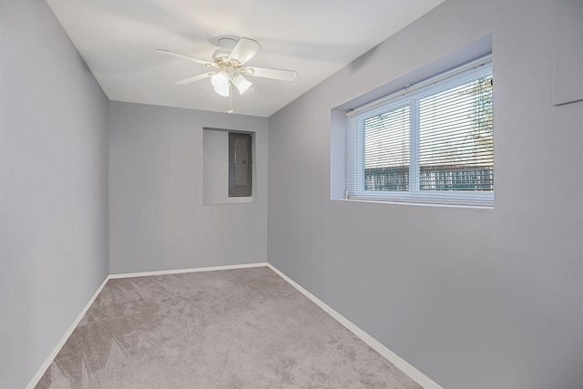 unfurnished room with light colored carpet, electric panel, and ceiling fan