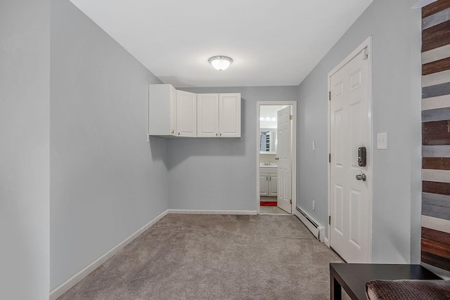 laundry area featuring light carpet and baseboard heating