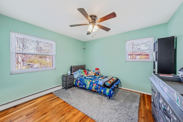 bedroom with ceiling fan, a baseboard radiator, and dark hardwood / wood-style floors