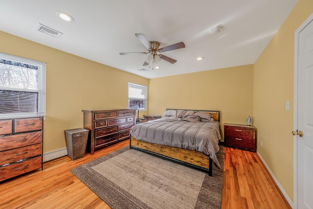 bedroom with ceiling fan, a baseboard radiator, and light hardwood / wood-style flooring