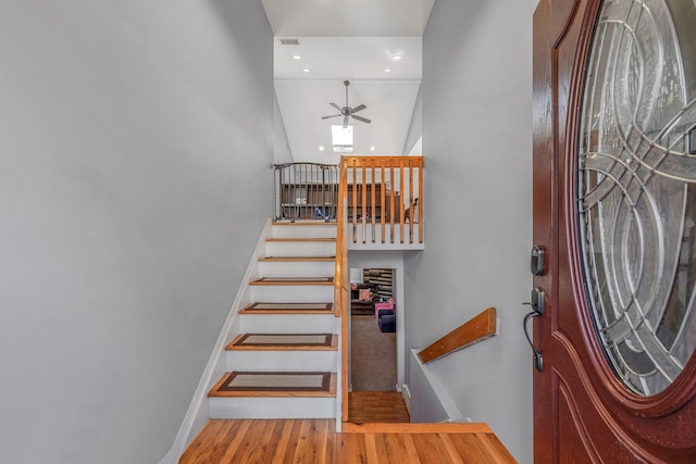 foyer with ceiling fan, hardwood / wood-style floors, and a towering ceiling