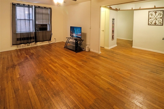 unfurnished living room featuring ceiling fan and light wood-type flooring