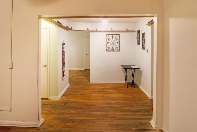 corridor with dark hardwood / wood-style flooring