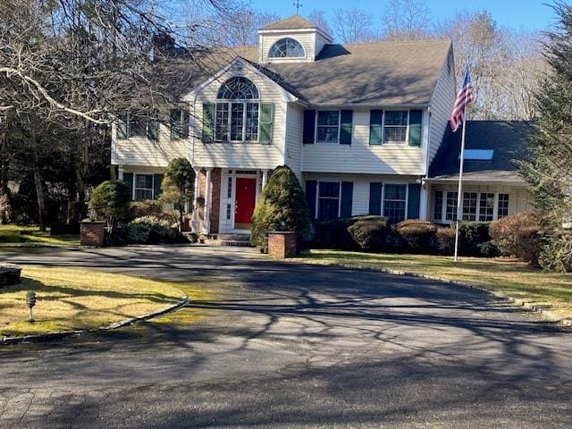 colonial home featuring a front lawn