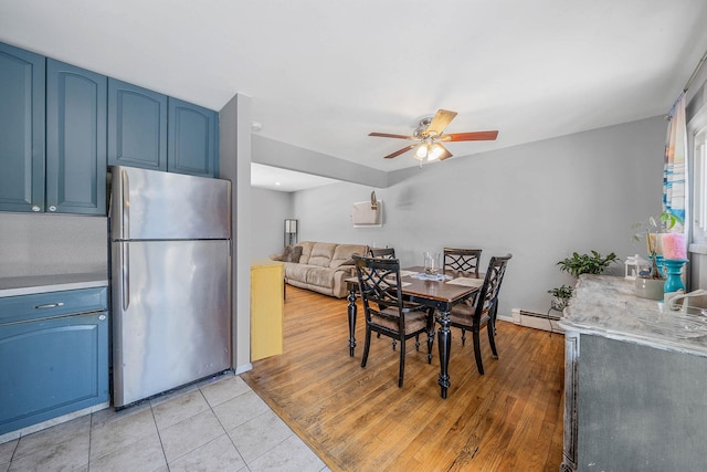 dining room with ceiling fan, light tile patterned floors, and baseboard heating