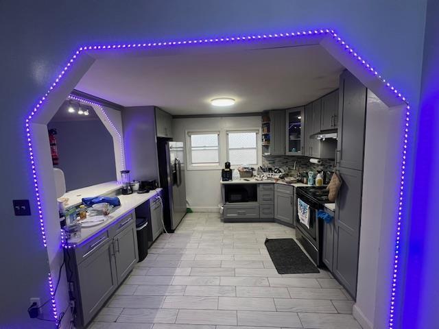 kitchen with electric stove, gray cabinets, tasteful backsplash, built in microwave, and stainless steel fridge with ice dispenser