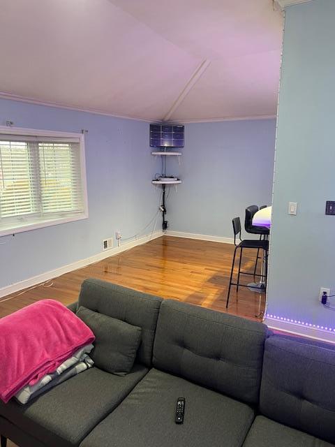 living room featuring wood-type flooring and vaulted ceiling