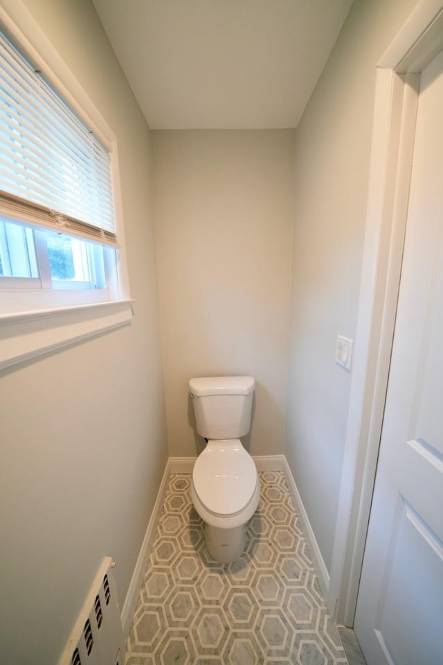 bathroom with tile patterned floors, toilet, and a baseboard heating unit