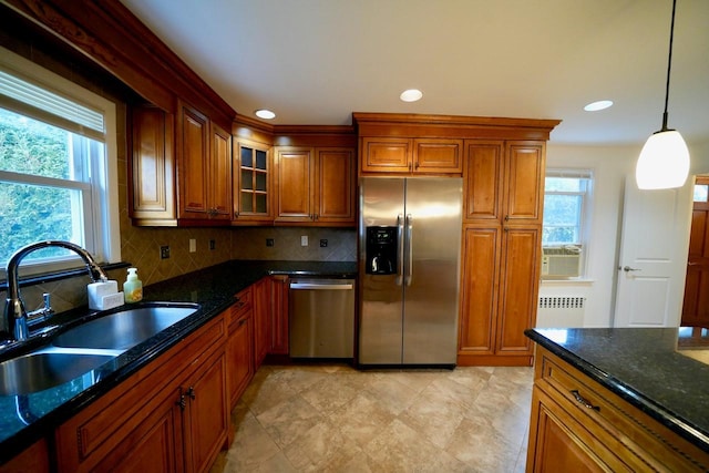 kitchen with pendant lighting, sink, appliances with stainless steel finishes, radiator heating unit, and tasteful backsplash