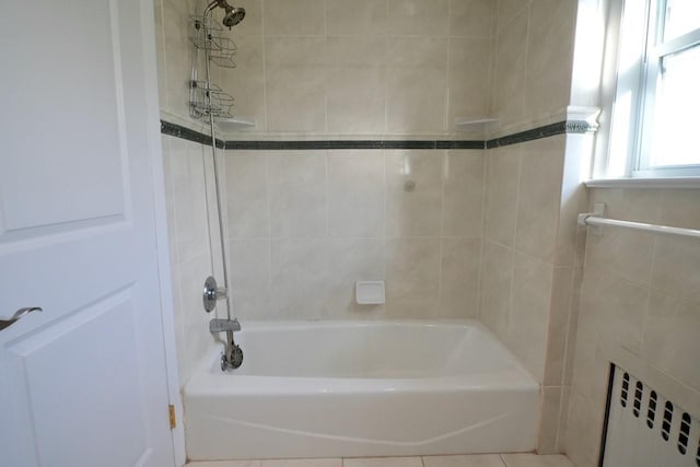 bathroom featuring tiled shower / bath combo and radiator