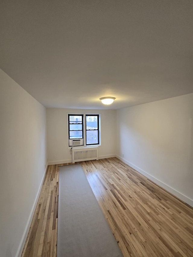 spare room with radiator and light hardwood / wood-style floors