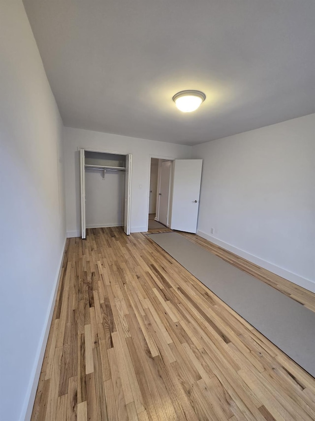 unfurnished bedroom featuring light hardwood / wood-style flooring and a closet