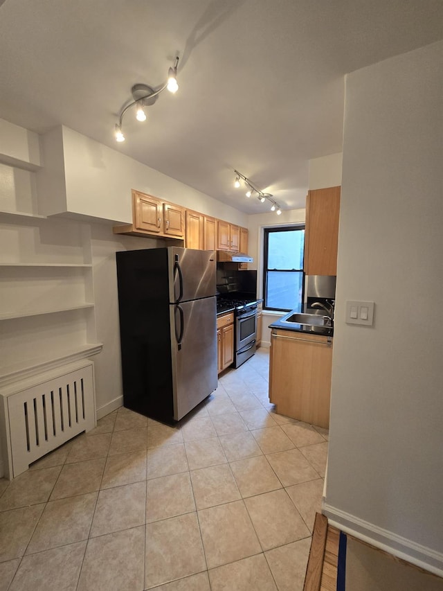 kitchen featuring sink, light tile patterned floors, radiator heating unit, stainless steel appliances, and light brown cabinetry