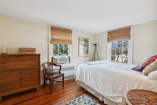 bedroom featuring dark wood-style flooring, cooling unit, and radiator