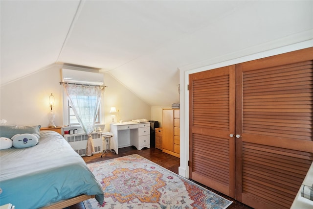 bedroom featuring radiator heating unit, dark wood-type flooring, vaulted ceiling, an AC wall unit, and a closet