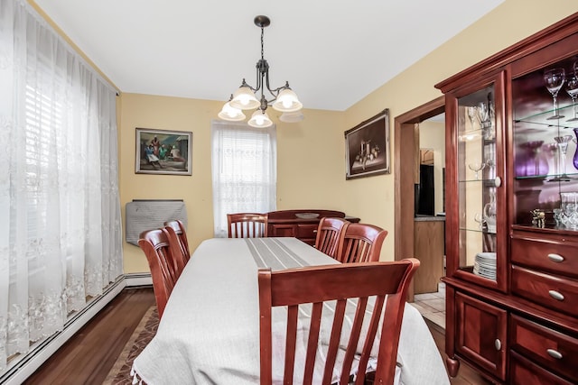 dining space featuring an inviting chandelier, baseboard heating, and wood finished floors