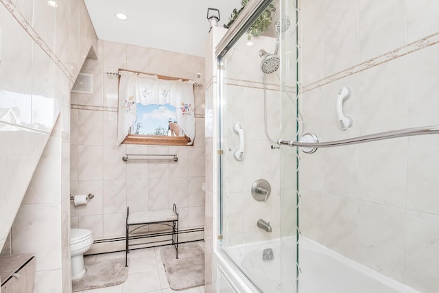 bathroom with toilet, shower / bath combination with glass door, tile walls, and baseboard heating