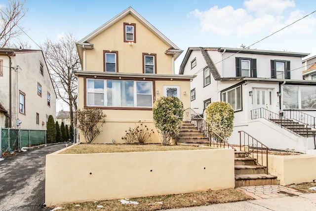 view of front of property with fence and stucco siding