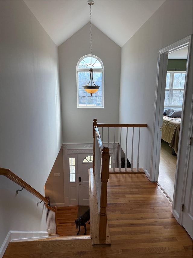 stairway with vaulted ceiling and wood finished floors