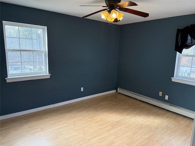 unfurnished room featuring a ceiling fan, light wood-style flooring, a baseboard heating unit, and baseboards