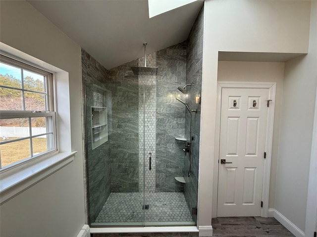 bathroom featuring a shower stall, baseboards, vaulted ceiling, and wood finished floors