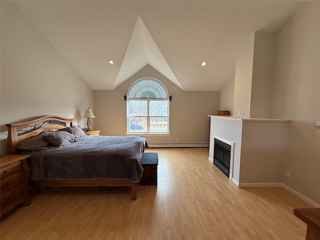 bedroom featuring a baseboard radiator, baseboards, vaulted ceiling, light wood finished floors, and a glass covered fireplace