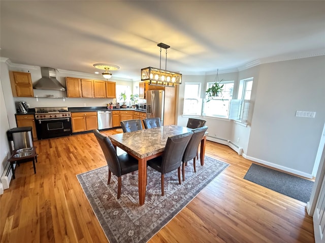 dining space with a baseboard heating unit, ornamental molding, light wood finished floors, and baseboards