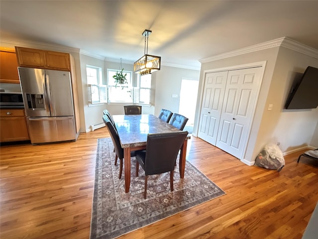 dining room featuring light wood-type flooring, baseboards, ornamental molding, and baseboard heating