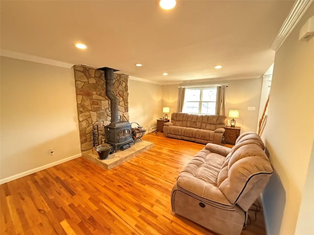 living area with a wood stove, light wood-style floors, and ornamental molding