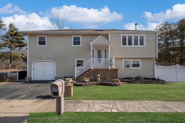 split foyer home featuring a garage and a front yard