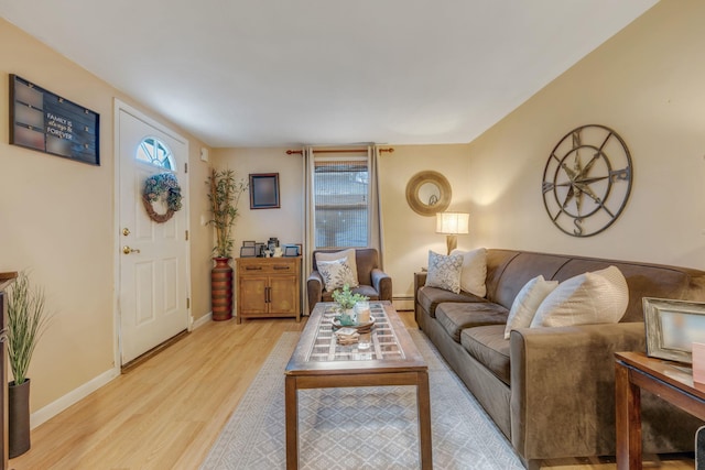 living room with plenty of natural light, light hardwood / wood-style floors, and baseboard heating