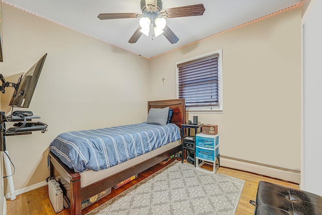 bedroom featuring ceiling fan, a baseboard radiator, and hardwood / wood-style floors