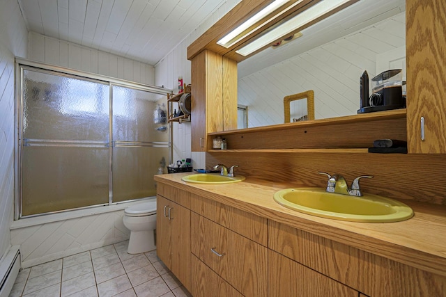 full bathroom featuring enclosed tub / shower combo, baseboard heating, vanity, tile patterned floors, and toilet