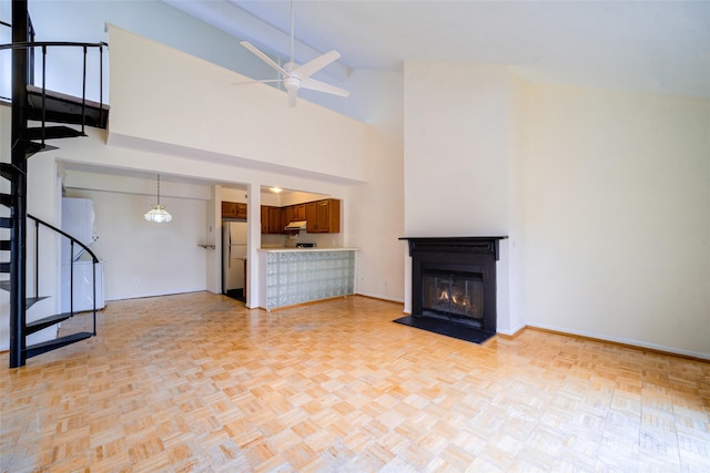 unfurnished living room featuring high vaulted ceiling, light parquet flooring, and ceiling fan