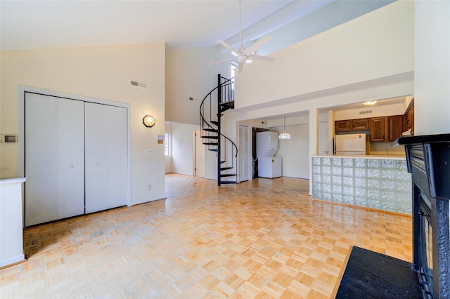 interior space with refrigerator, high vaulted ceiling, dark brown cabinets, ceiling fan, and light parquet floors