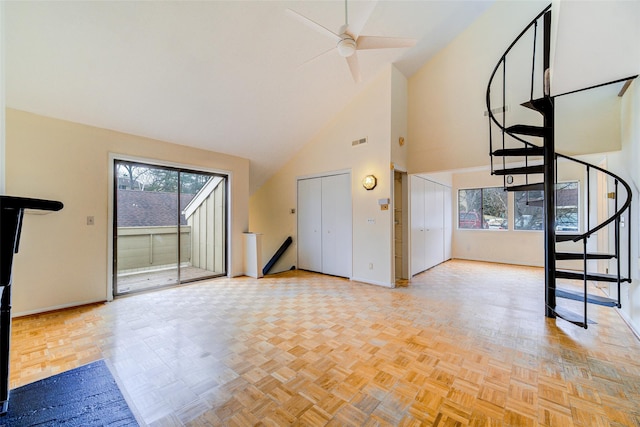 unfurnished living room featuring plenty of natural light, high vaulted ceiling, and light parquet flooring