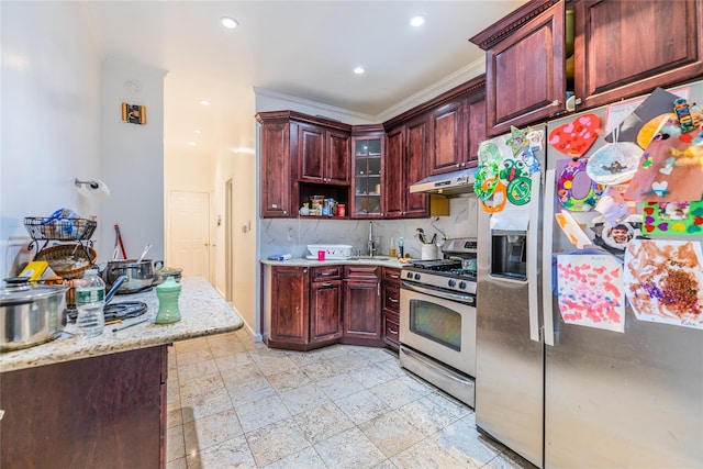 kitchen with light stone counters, decorative backsplash, ornamental molding, and stainless steel appliances