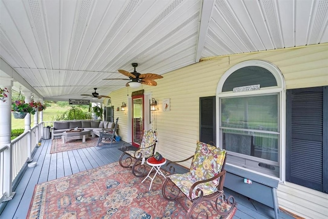 deck with ceiling fan, an outdoor living space, and a porch