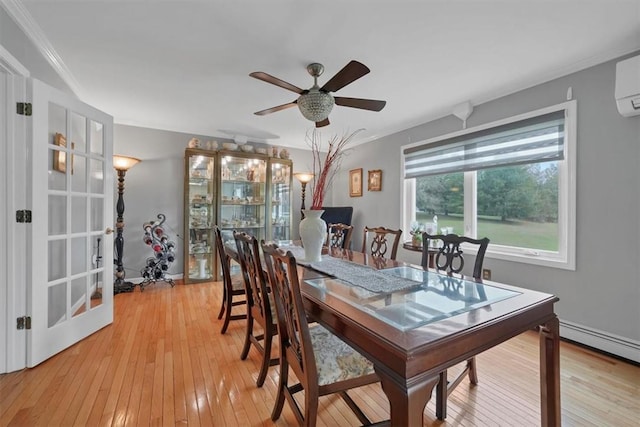 dining space with baseboard heating, ceiling fan, ornamental molding, and light wood-type flooring