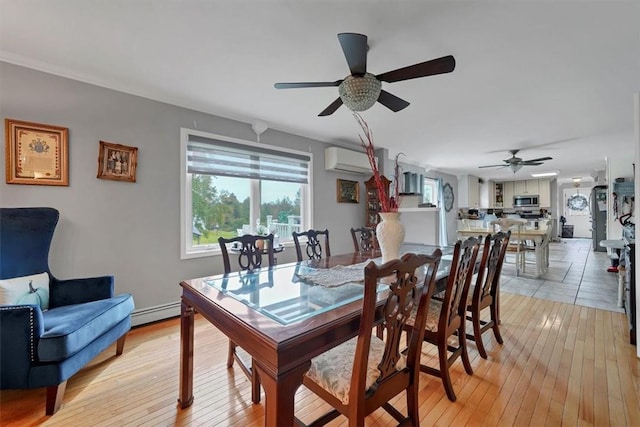 dining space with ceiling fan, a baseboard heating unit, a wall mounted air conditioner, and light hardwood / wood-style floors