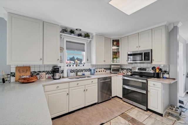 kitchen with stainless steel appliances, white cabinetry, sink, and decorative backsplash