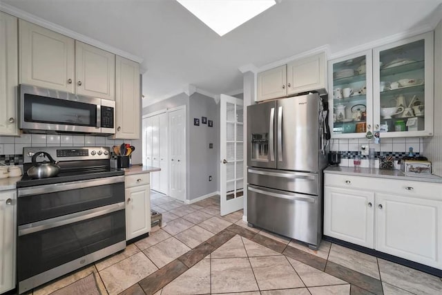 kitchen with stainless steel appliances, tasteful backsplash, and crown molding