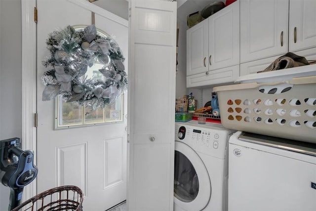 laundry room featuring cabinets and washer and clothes dryer