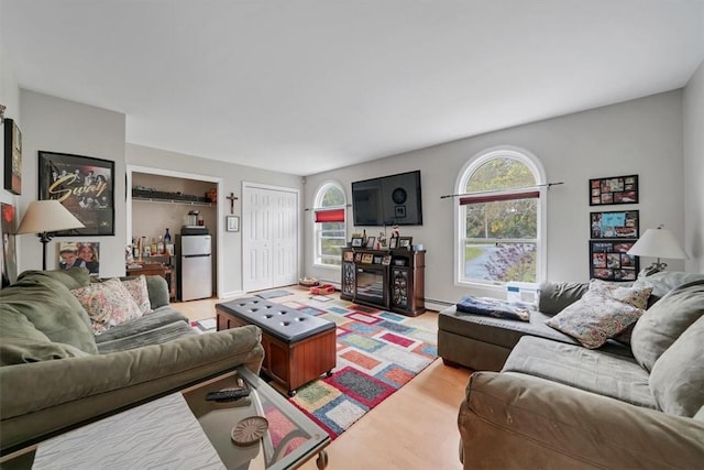 living room featuring a baseboard radiator and a wealth of natural light