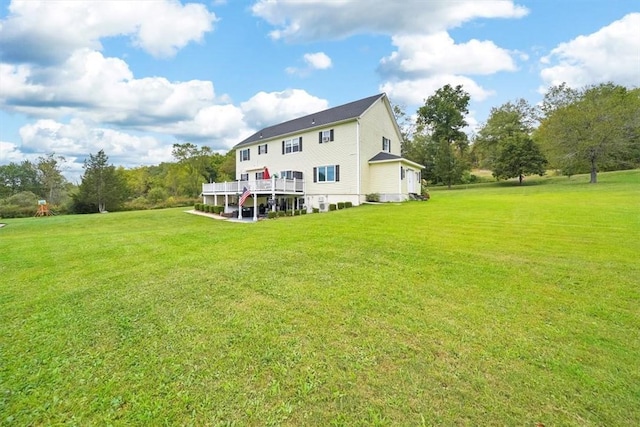 back of house with a deck and a lawn