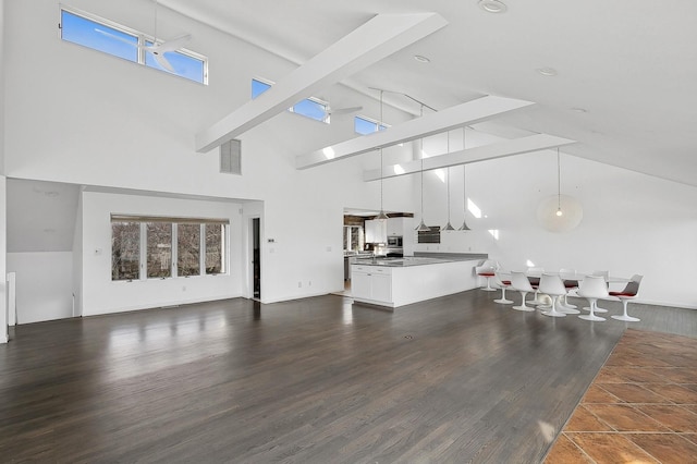 living room with dark wood-type flooring, high vaulted ceiling, and beamed ceiling