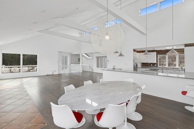 dining space with beam ceiling, high vaulted ceiling, and dark hardwood / wood-style floors