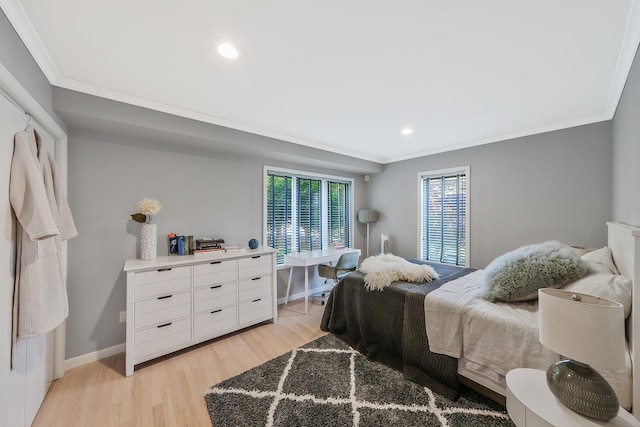 bedroom with ornamental molding and light hardwood / wood-style floors